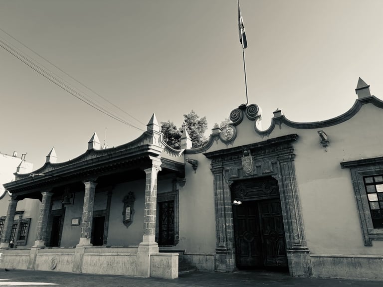 Traditional Chinese temple with upturned eaves, ornate roof details, and white walls against a cloudy sky